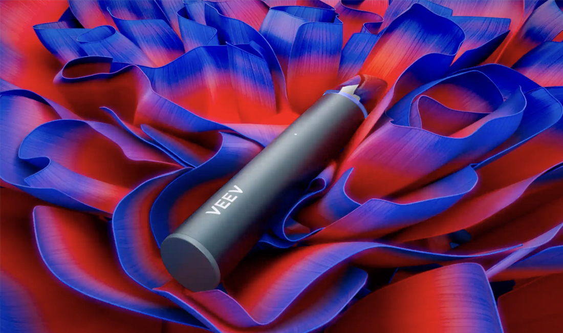VEEV now ULTRA disposable vape lying on a colourful VEEV themed flower display