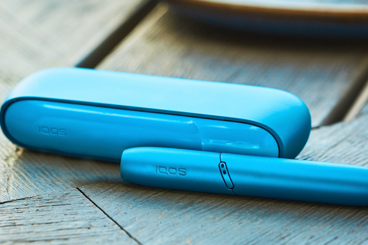 IQOS ORIGINALS DUO Turquoise Kit placed on a wooden table