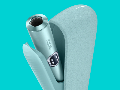 Vue de haut de l'appareil IQOS ILUMA i (stylet + chargeur de poche) couleur Aigue-Marine sur un fond bleu turquoise