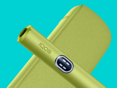 Appareil IQOS ILUMA i (stylet + chargeur de poche) couleur Vert Anis posé sur un fond turquoise