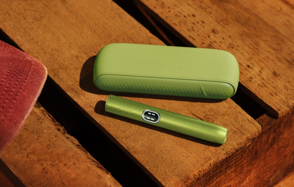 Photo vue de face de 1 Kit IQOS ILUMA i vert anis sur table en bois.