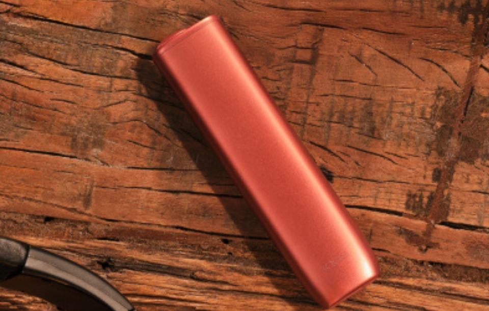 Photo vue de face de 1 Kit IQOS ILUMA i one couleur terracotta sur table en bois.