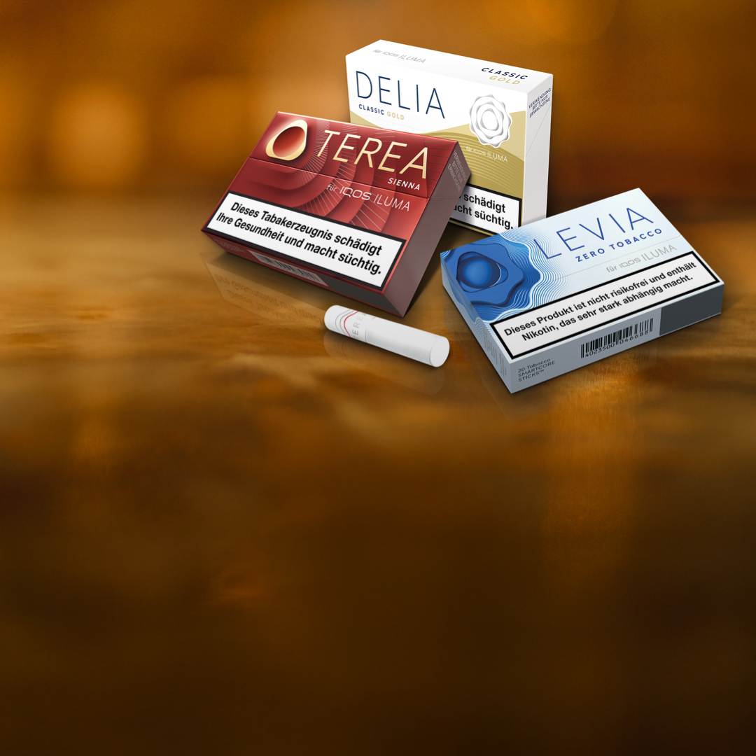 Je eine Packung TEREA Tabaksticks, DELIA Tabaksticks und LEVIA Nikotinsticks liegen auf einer braunen Holzplatte.