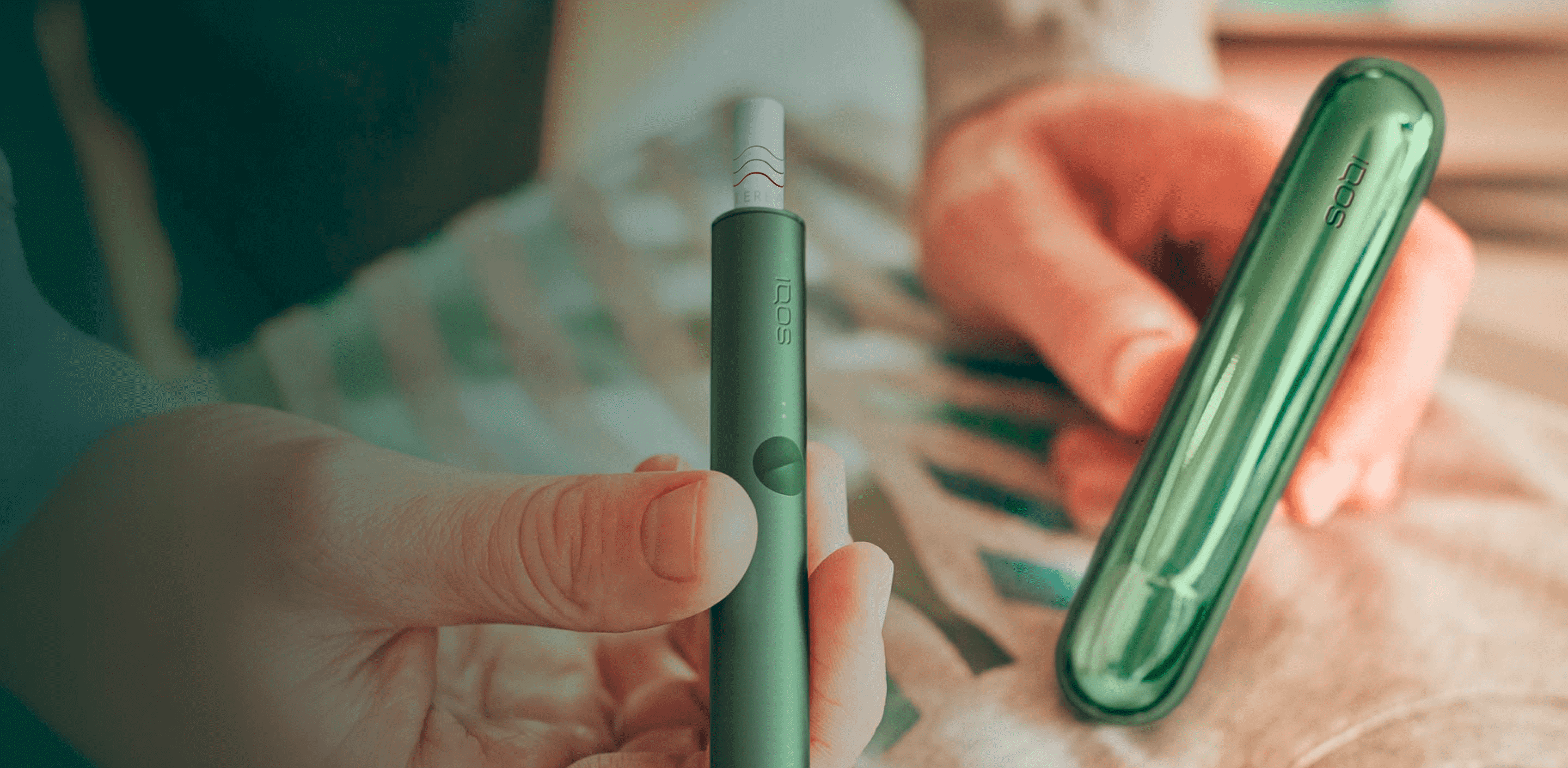 Jemand hält ein IQOS ILUMA Moss Green.