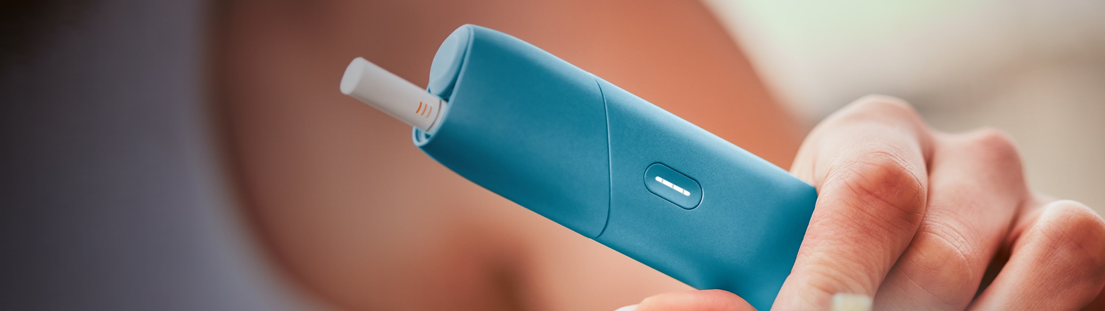 Jemand hält ein blaues IQOS Originals One