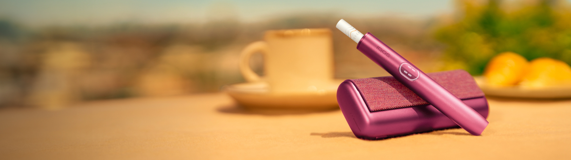 IQOS ILUMA i Tabekerhitzer in der Farbe Garnet Red dargestellt auf einem Holztisch