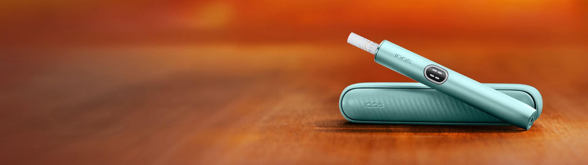 IQOS ILUMA i Tabekerhitzer in der Farbe Breeze Blue dargestellt auf einem Holztisch.