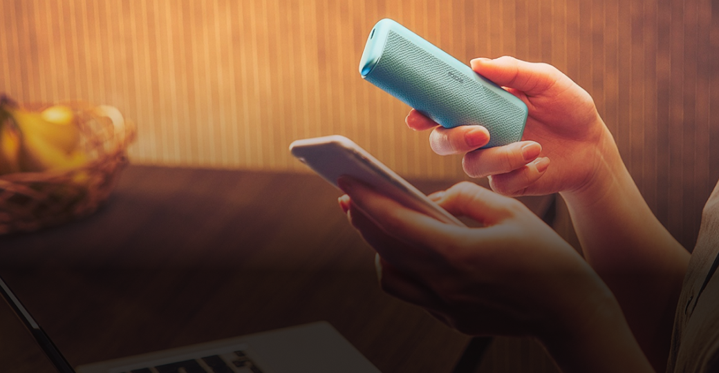 Jemand hält ein IQOS ILUMA i PRIME neben einem Smartphone