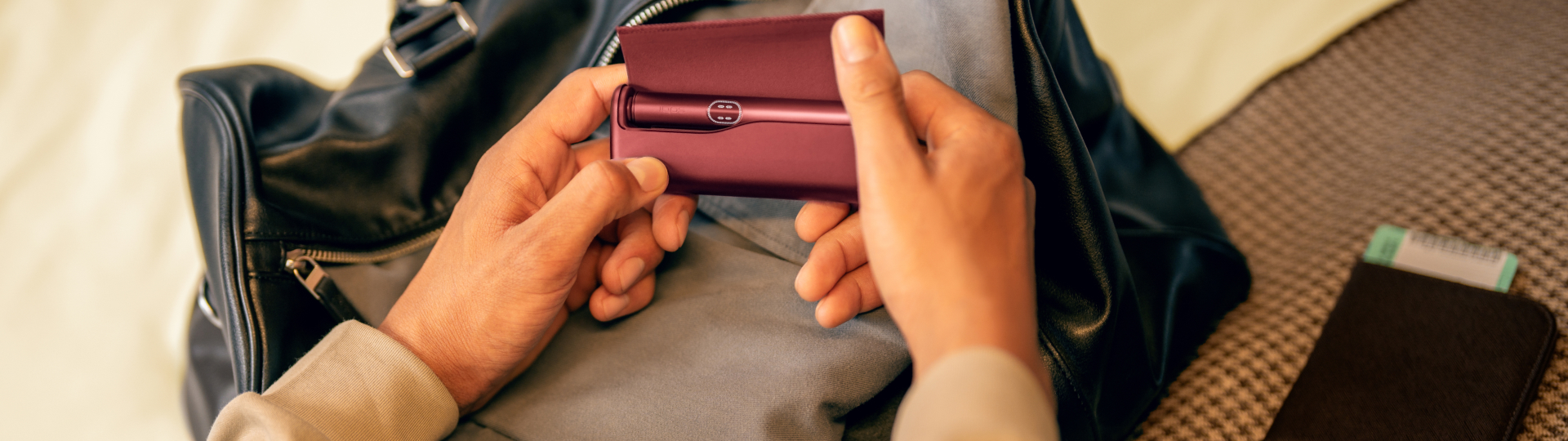 Person hält IQOS Tabakerhitzer in der Hand.