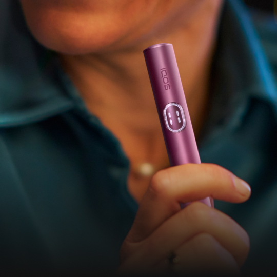 Person hält einen IQOS ILUMA i Holder