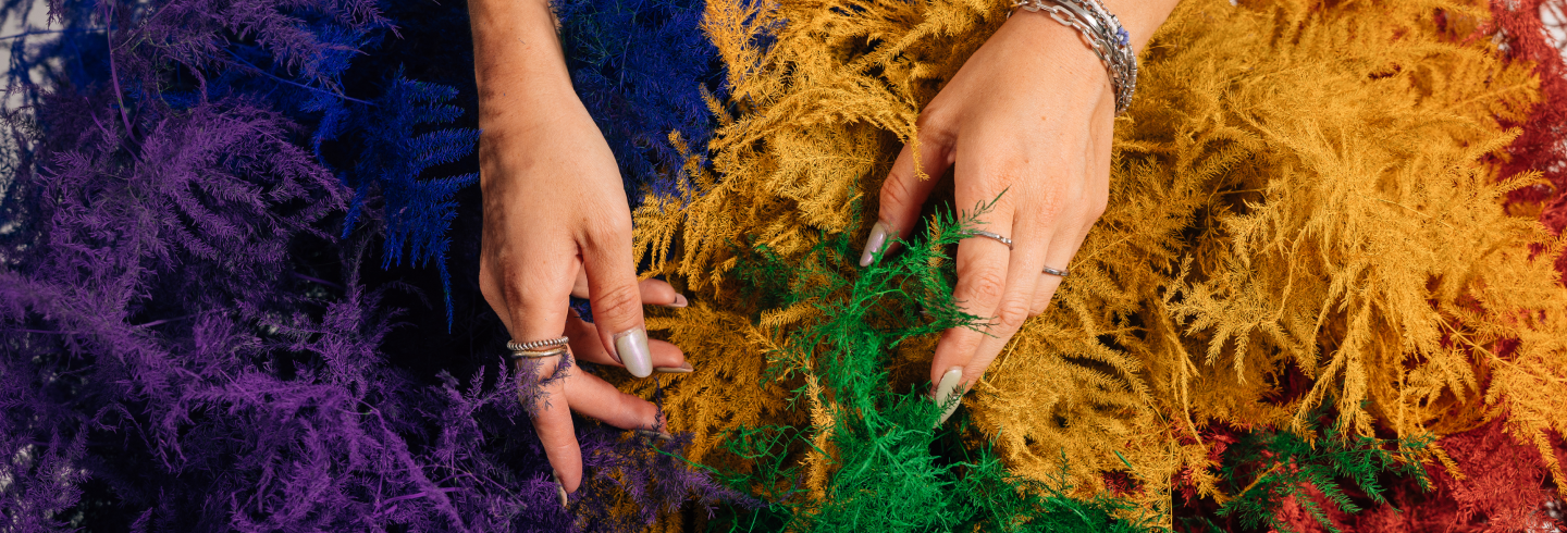 Hände vor einem Hintergrund mit bunten Blumen