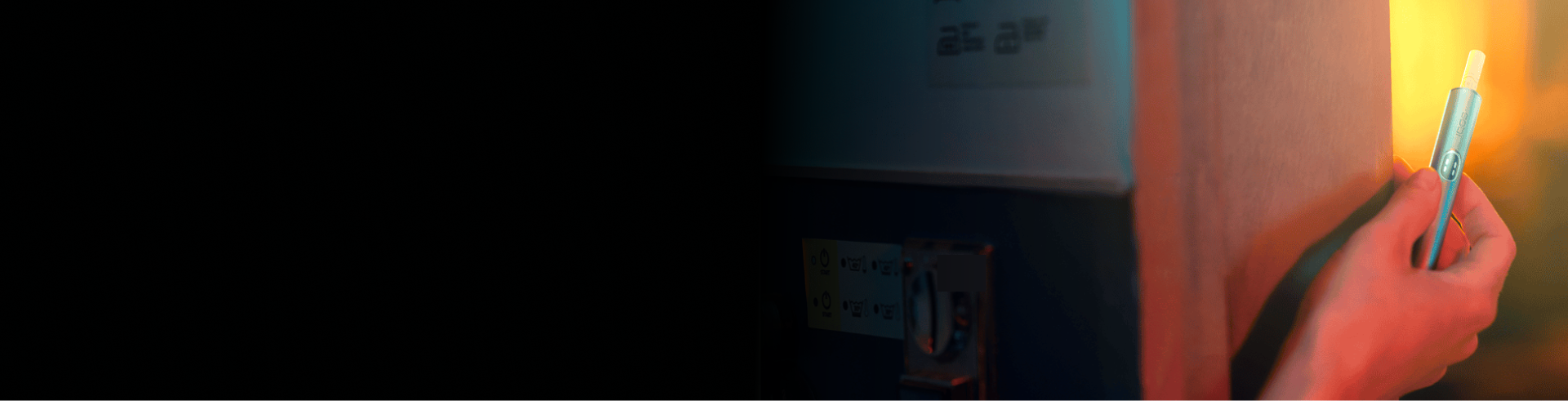 Eine Person hält einen IQOS ILUMA i Holder