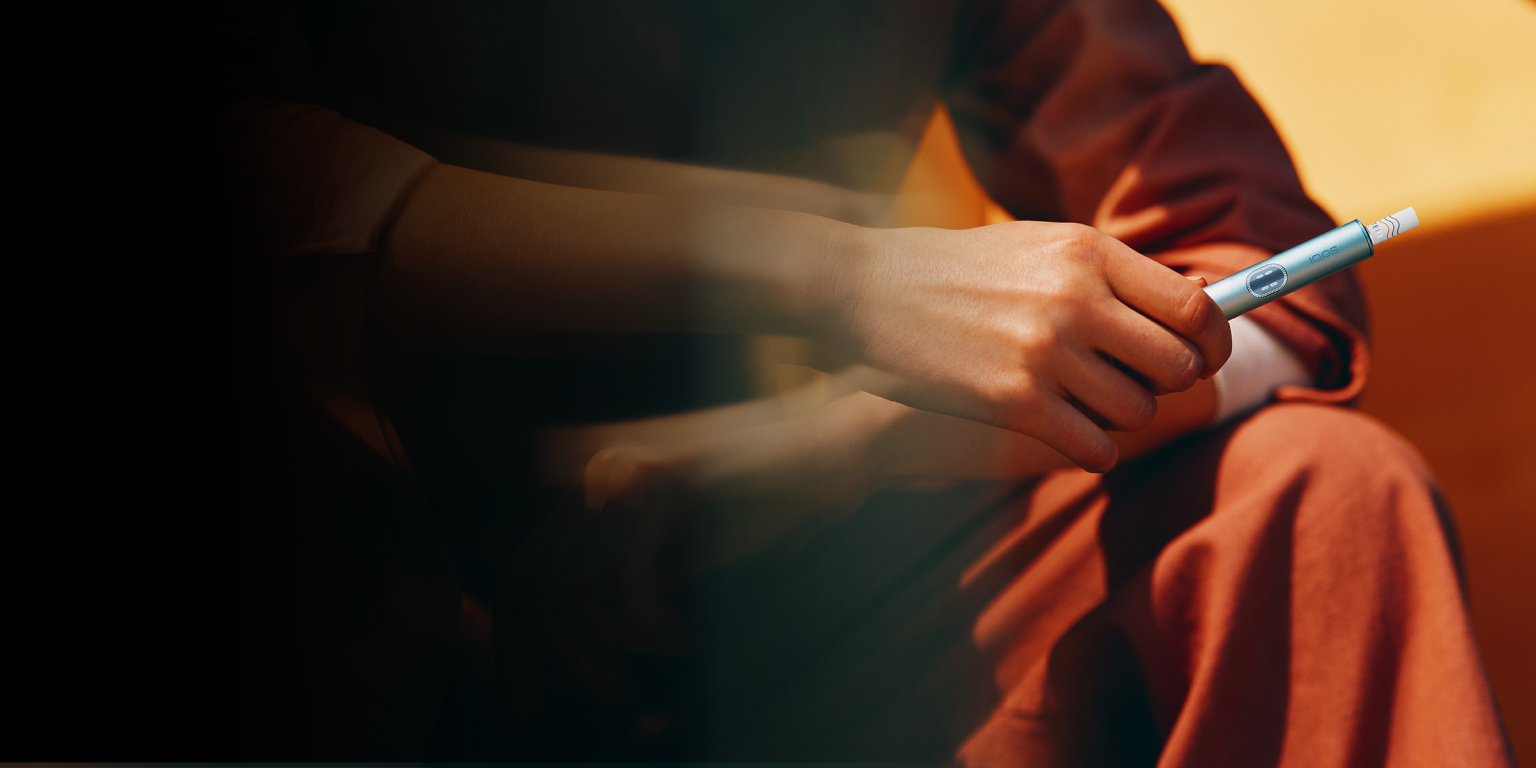 Person hält einen IQOS ILUMA i Holder