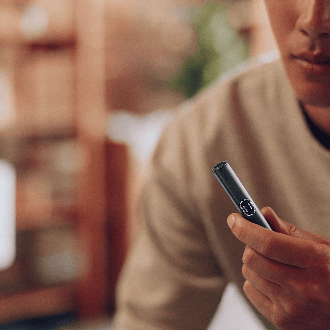 Persona sosteniendo un IQOS ILUMA i PRIME en Color Midnight Black en la mano