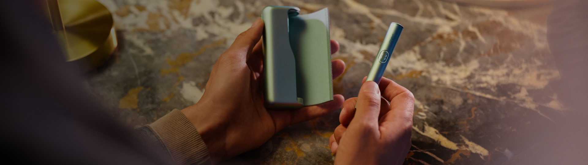 Persona sosteniendo un IQOS ILUMA i  color Breeze Blue