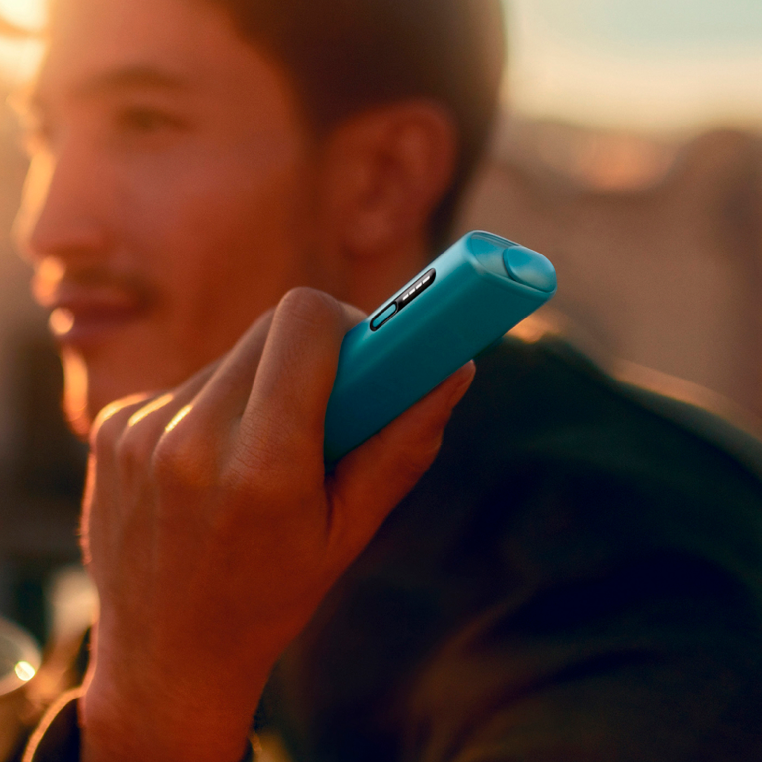 IQOS ILUMA i ONE color breeze blue sobre un cuaderno