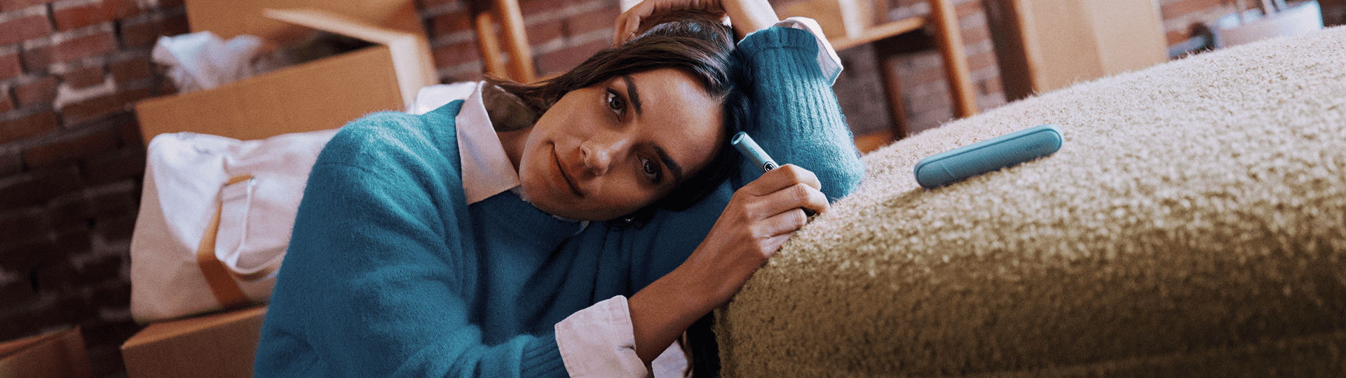 Mujer sosteniendo un IQOS ILUMA i color Breeze Blue