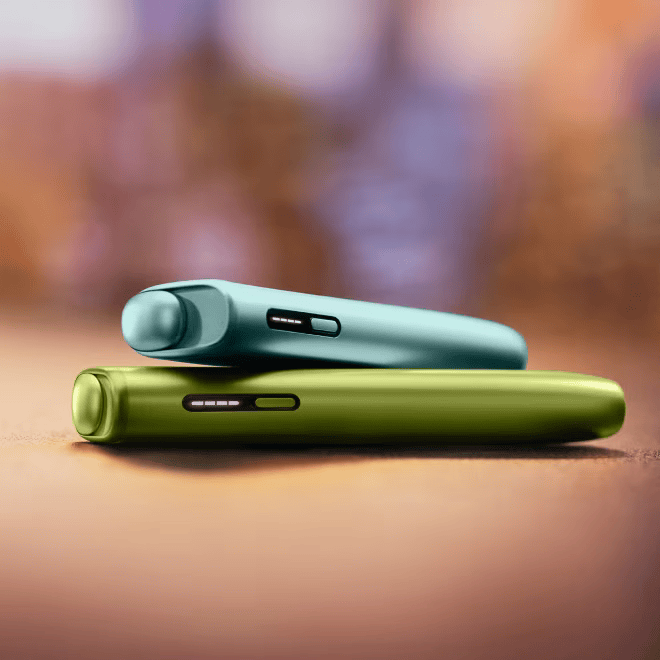 Plavi IQOS ILUMA i ONE uređaj na zelenom IQOS ILUMA i ONE uređaju