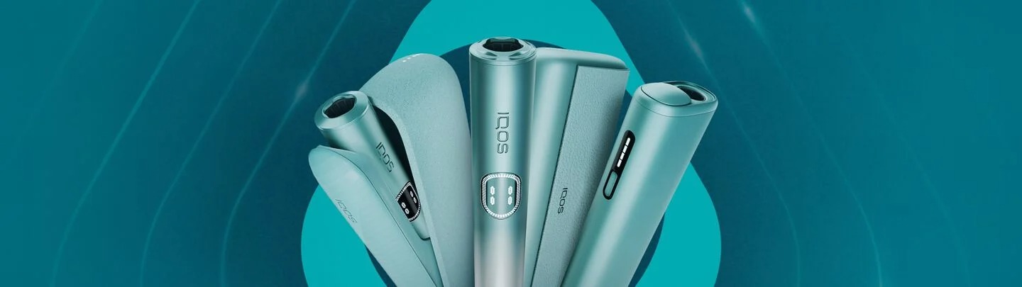 Line-up of IQOS ILUMA i Prime devices in teal with holders and cases, displayed against a turquoise background.