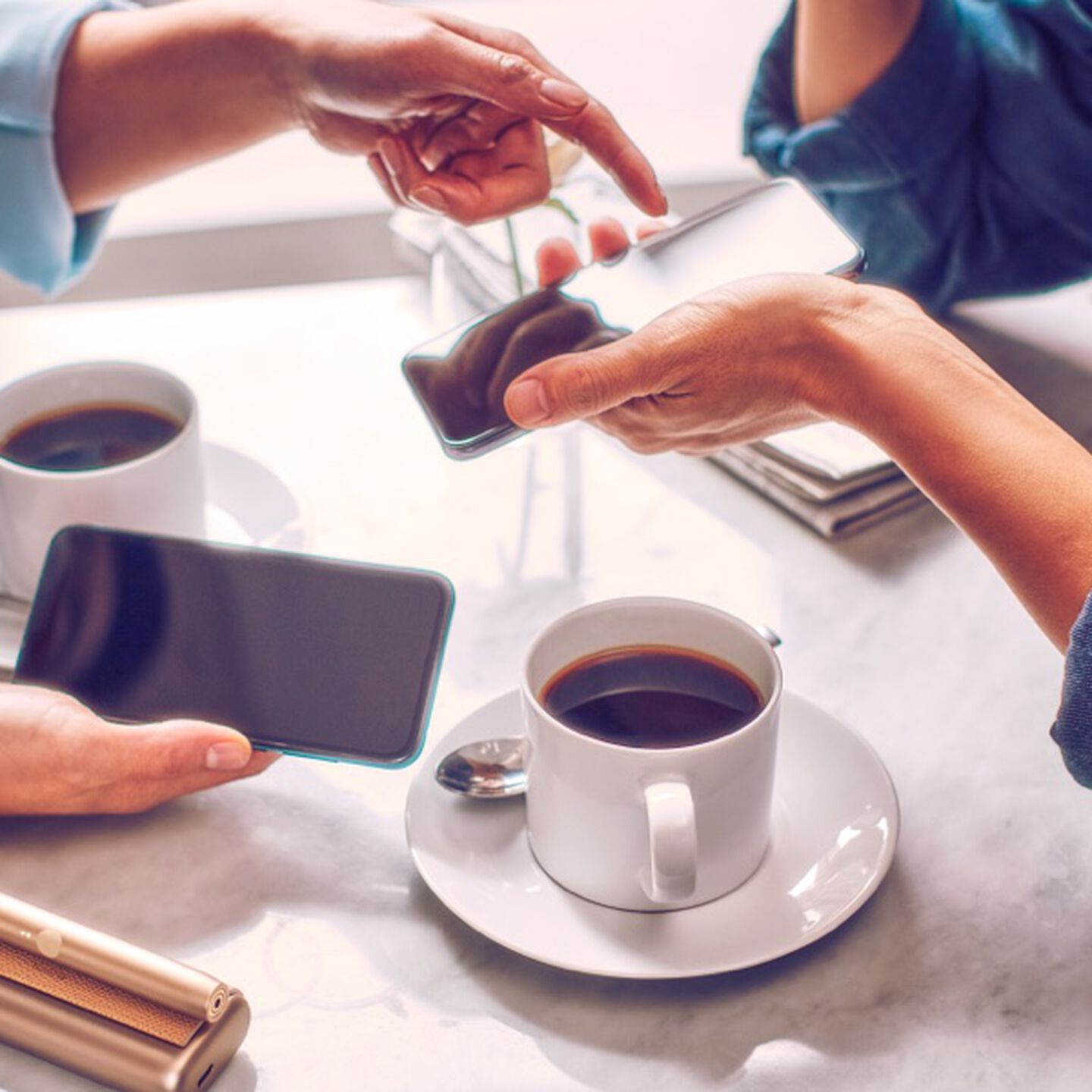 Two people with mobile phones having coffee