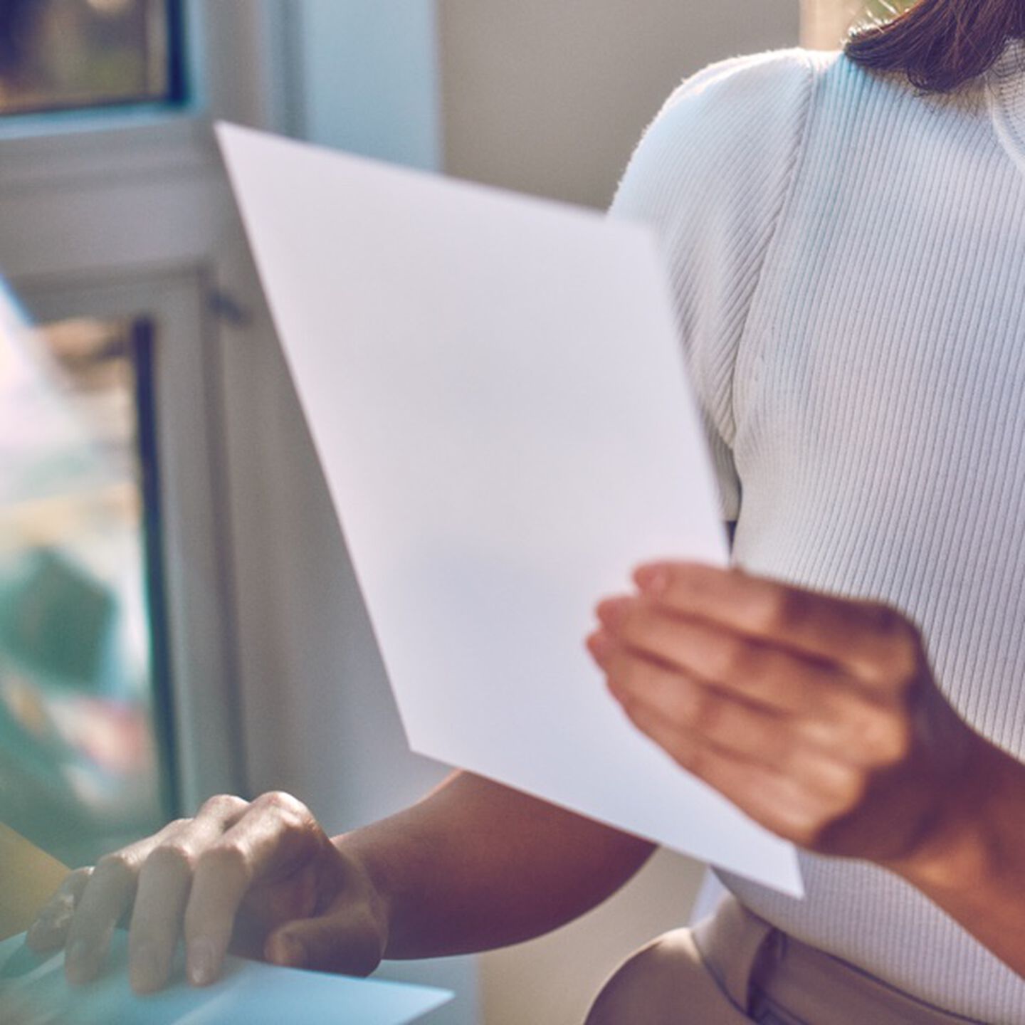 A person holding a sheet of paper