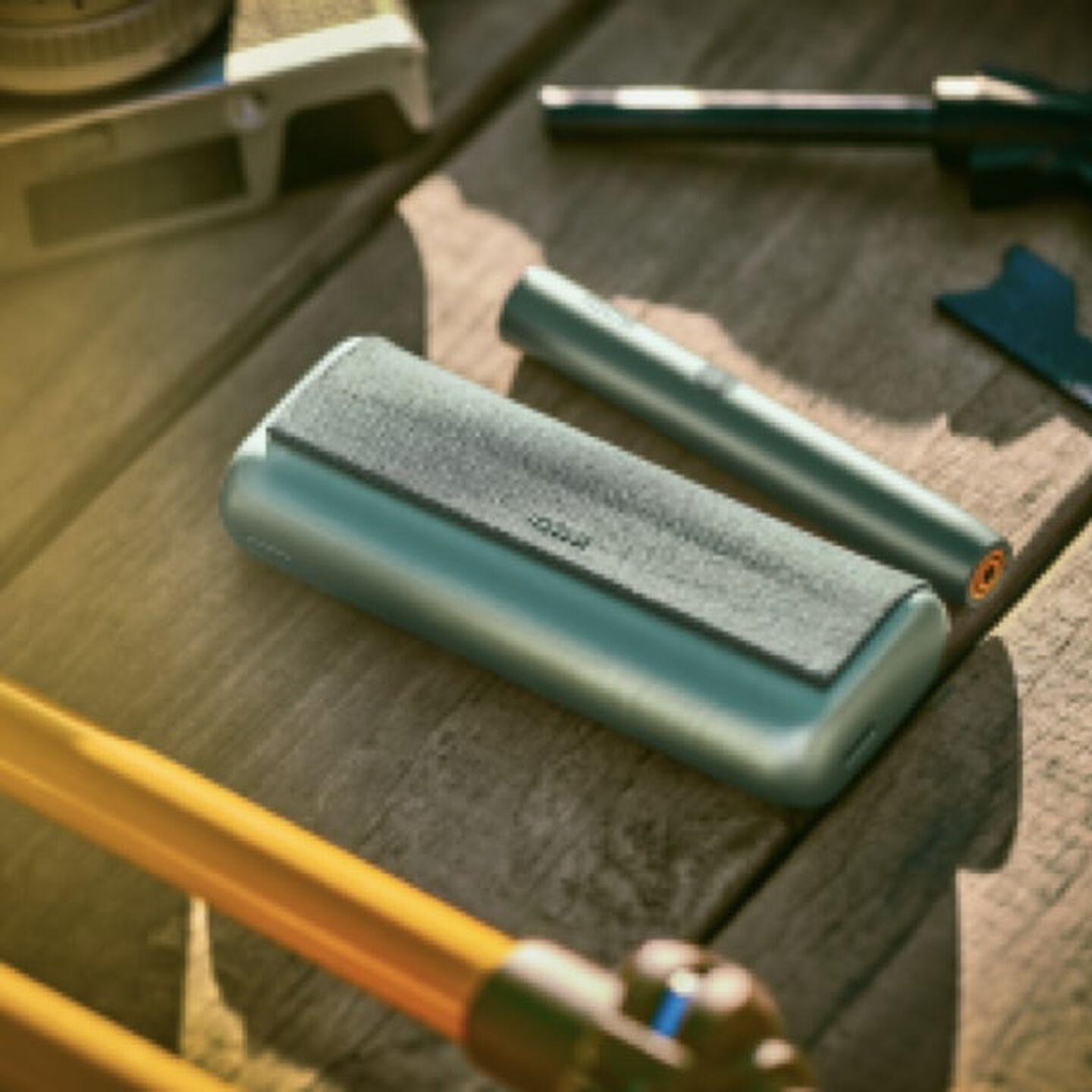 A person placing an IQOS ILUMA Pocket Charger into a charging station.