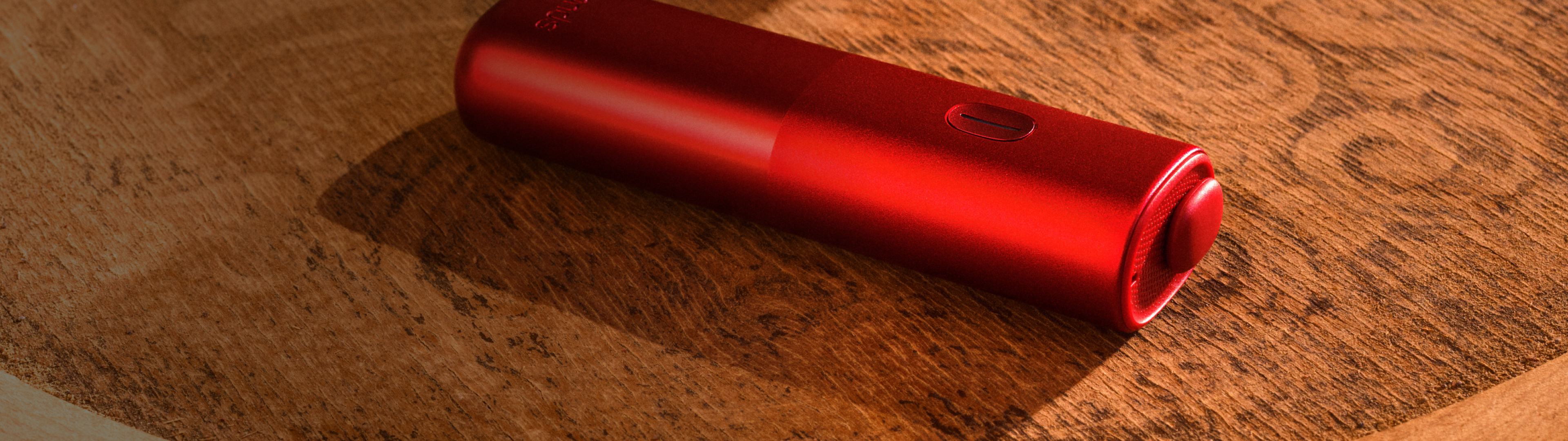 Appareil Red BONDS by IQOS sur une table en bois.