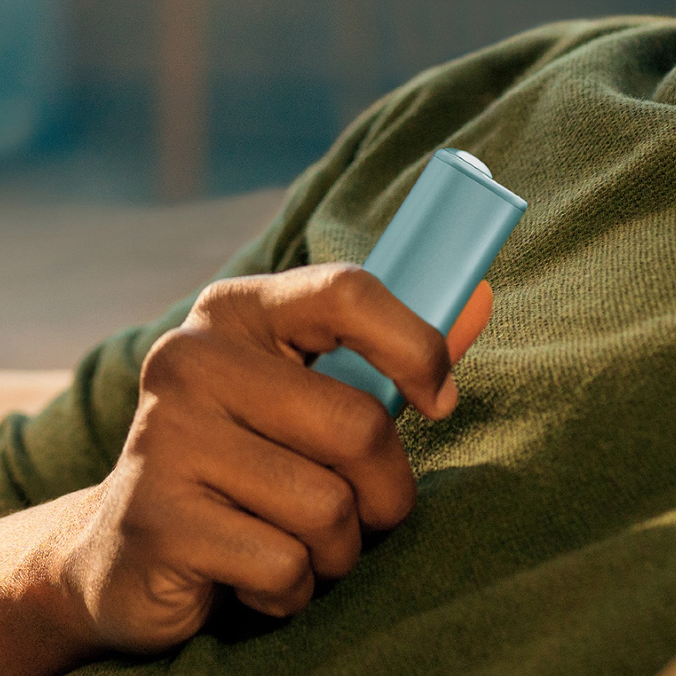 A person holding Breeze Blue IQOS ILUMA i ONE device.