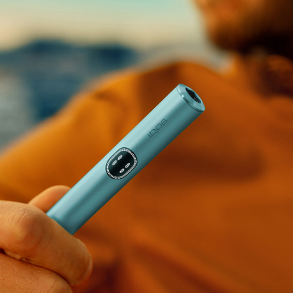 A person holding a Breeze Blue IQOS ILIUMA I holder.