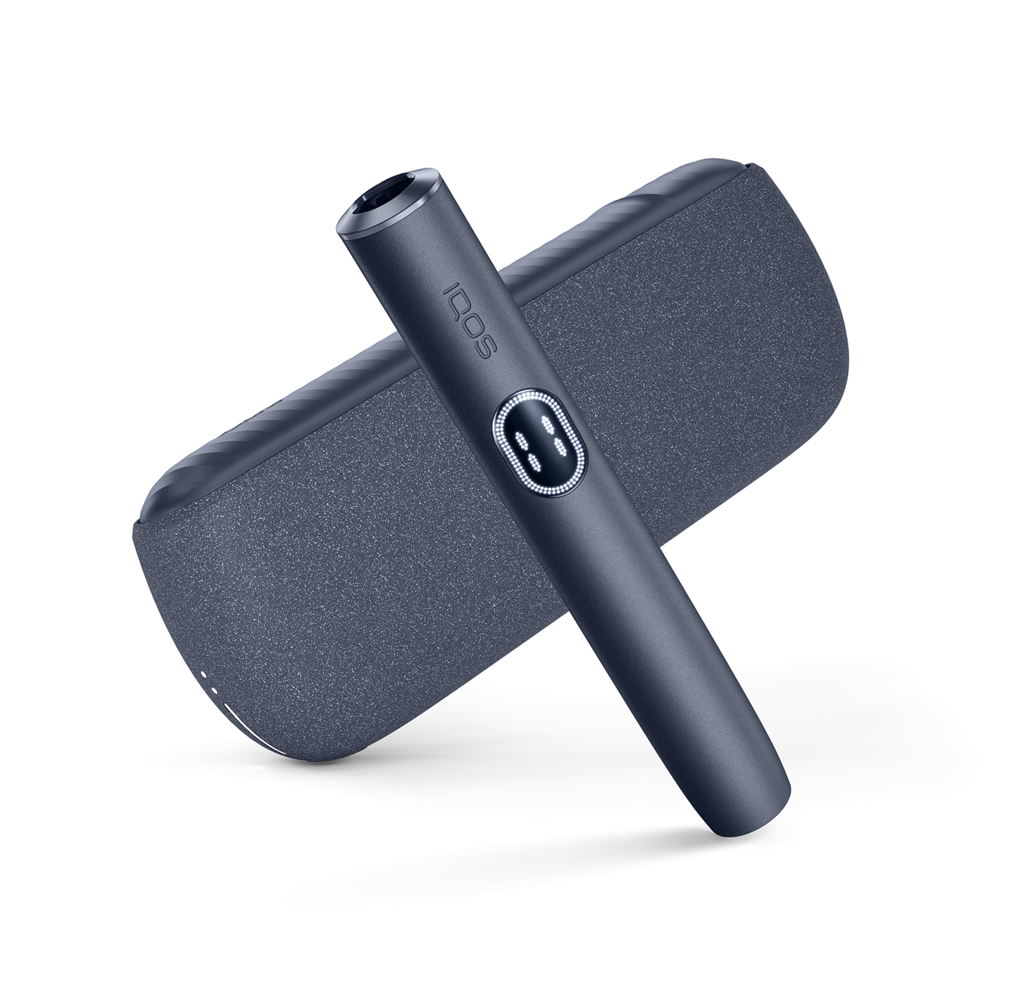 IQOS Iluma i ONE gris sobre cargador negro en composición diagonal