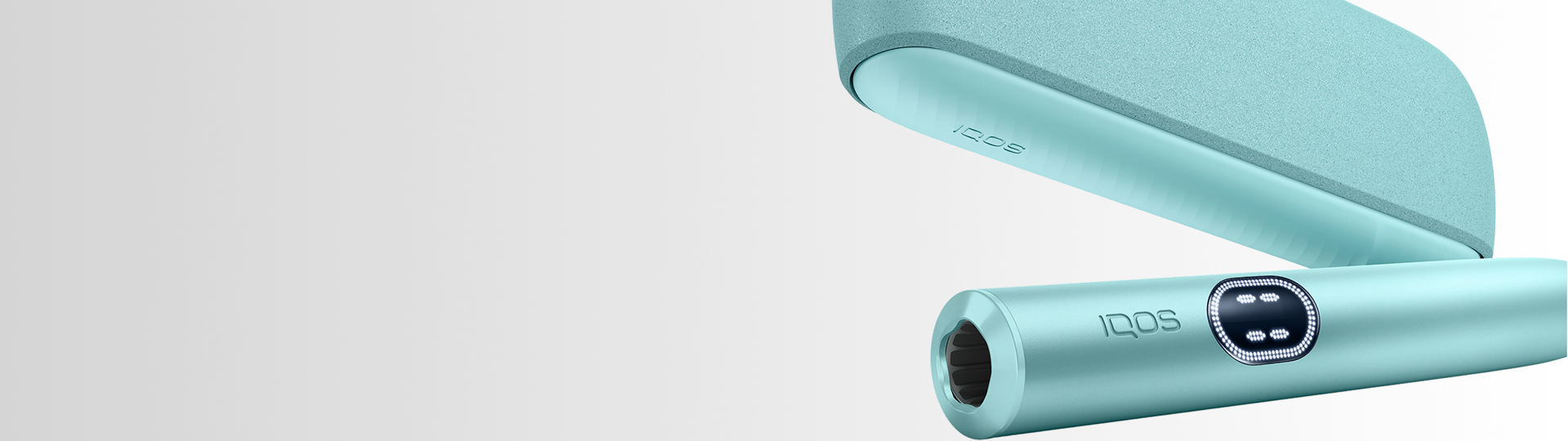 IQOS Iluma i turquesa con cargador pastel abierto sobre superficie gris clara