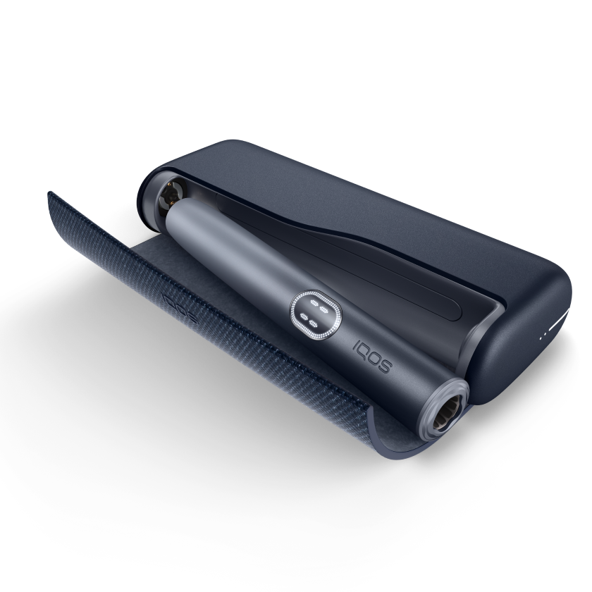 IQOS ILUMA PRIME color gris oscuro con tapa abierta mostrando el interior, acompañado de texto “Mantén la batería cargada”