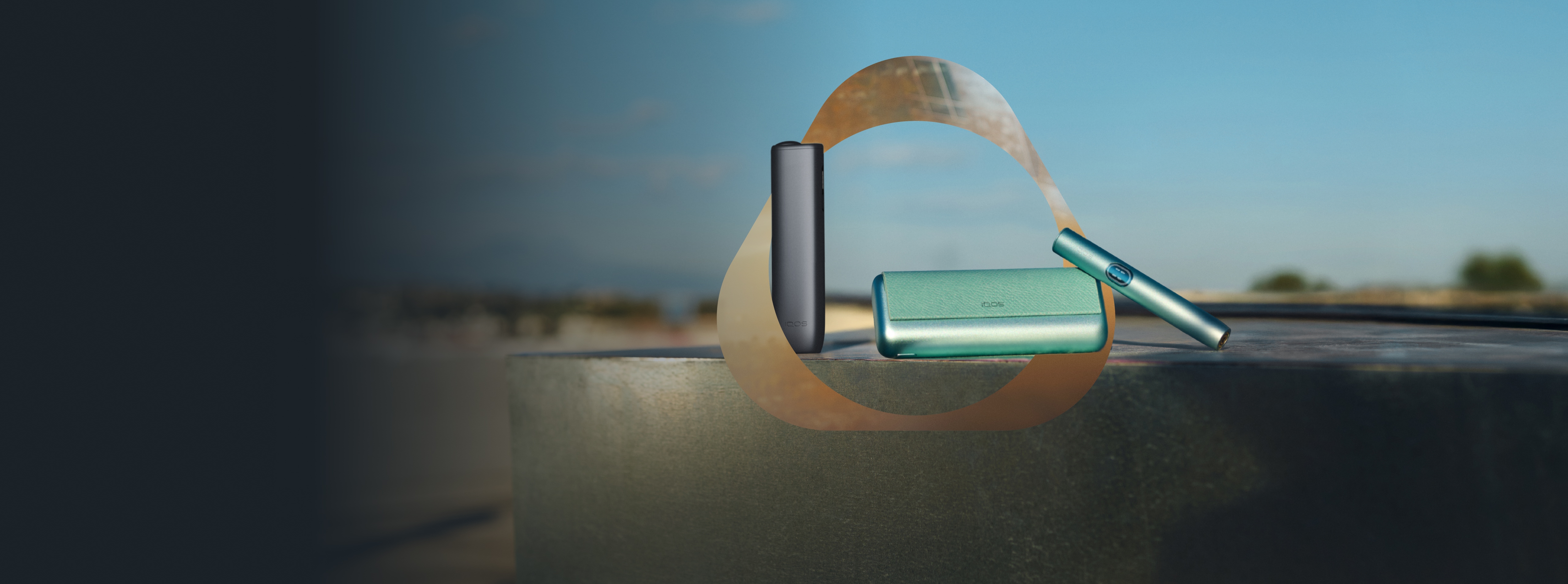 Dispositivo IQOS ILUMA i color breeze blue con holder,y IQOS ILUMA i ONE color midnight, sobre fondo con diseño circular y texto “Nuevo IQOS ILUMA i. Modo Pausa, Botón Táctil y mucho más”.