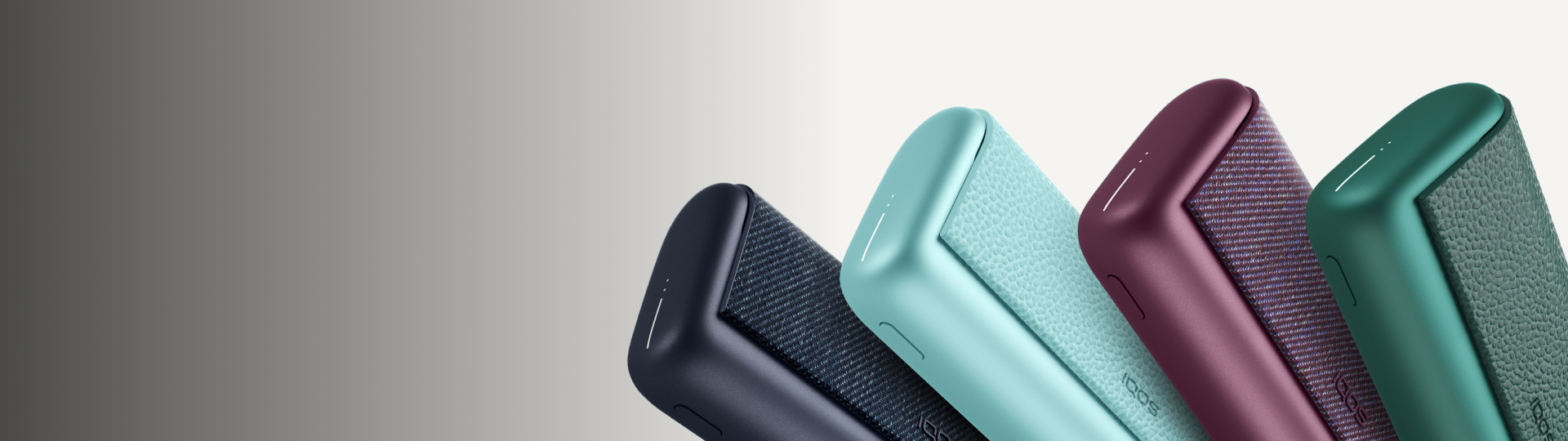 Persona usando IQOS Iluma i turquesa junto a taza de café sobre mesa metálica