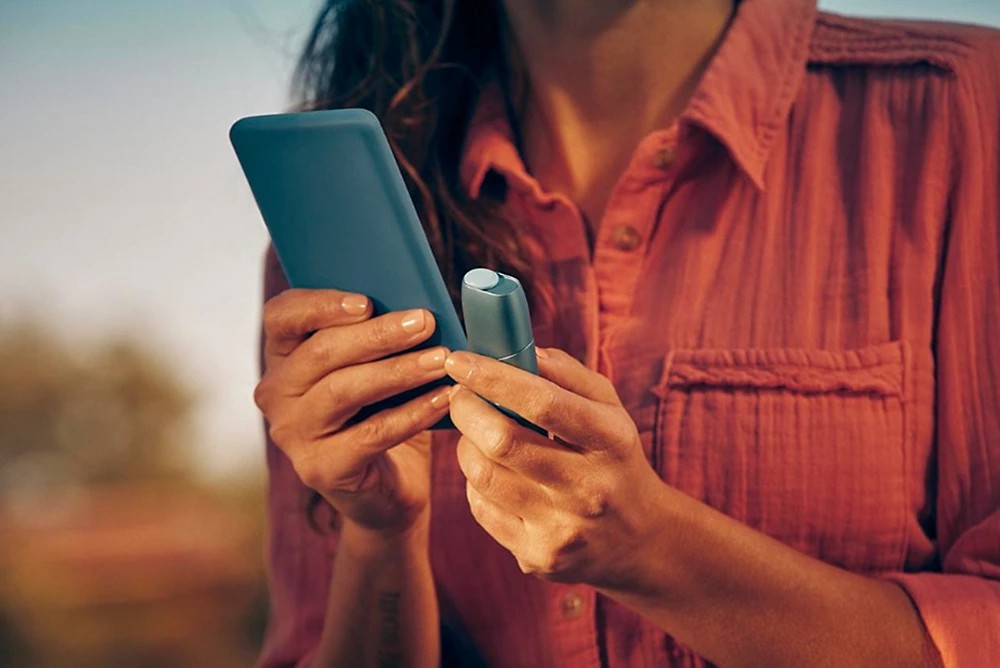 Woman holding an IQOS device