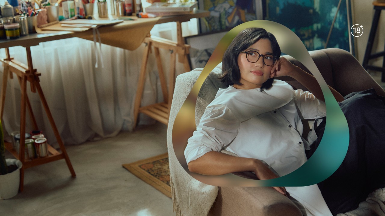 Creative studio scene featuring collaborator artist Isabel Santos relaxing on a sofa, surrounded by art materials.