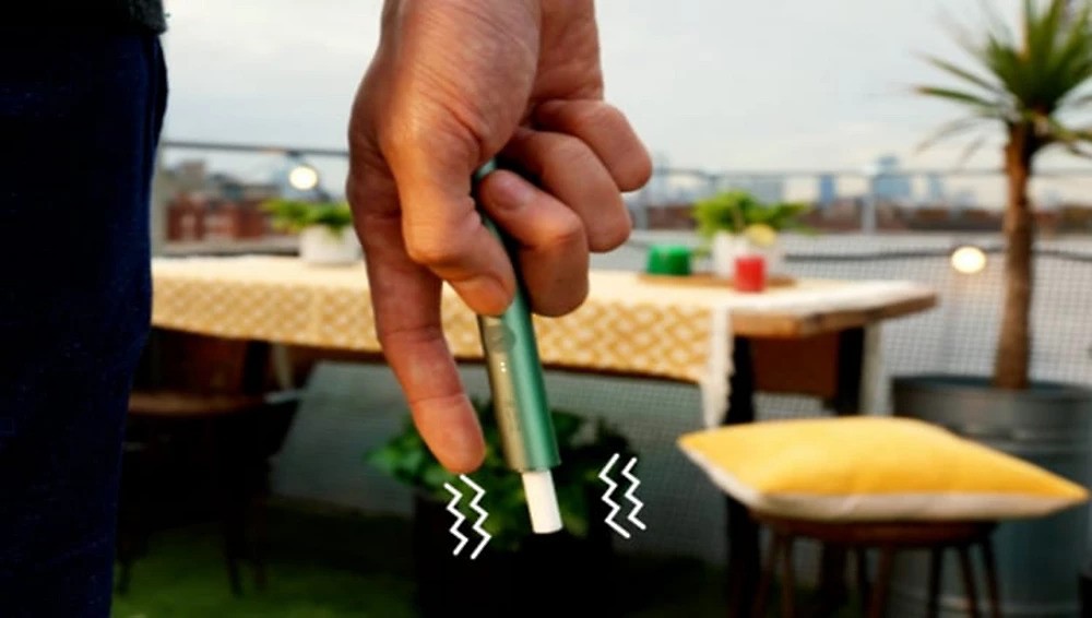 An illustration showing how IQOS ILUMA PRIME is responsive to hand gestures.