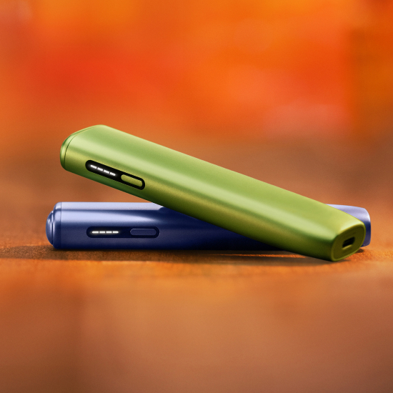 Zelena naprava IQOS ILUMA i ONE na vijolični napravi IQOS ILUMA i ONE