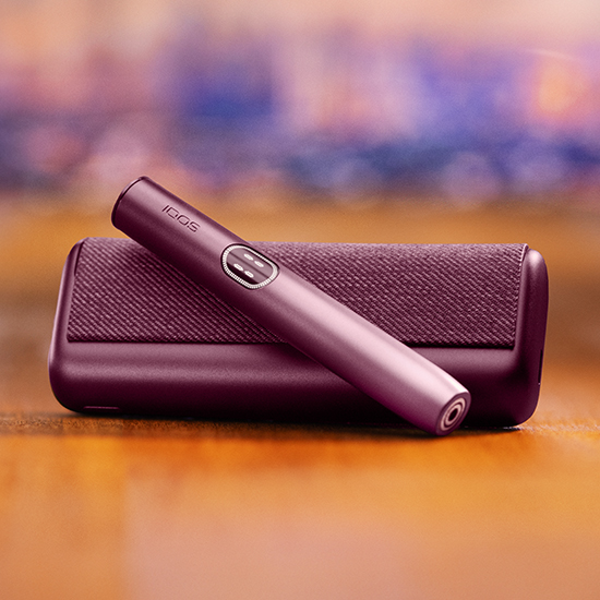 Držalo naprave IQOS ILUMA i PRIME v bordo barvi Garnet Red na žepnem polnilniku, z etuijem