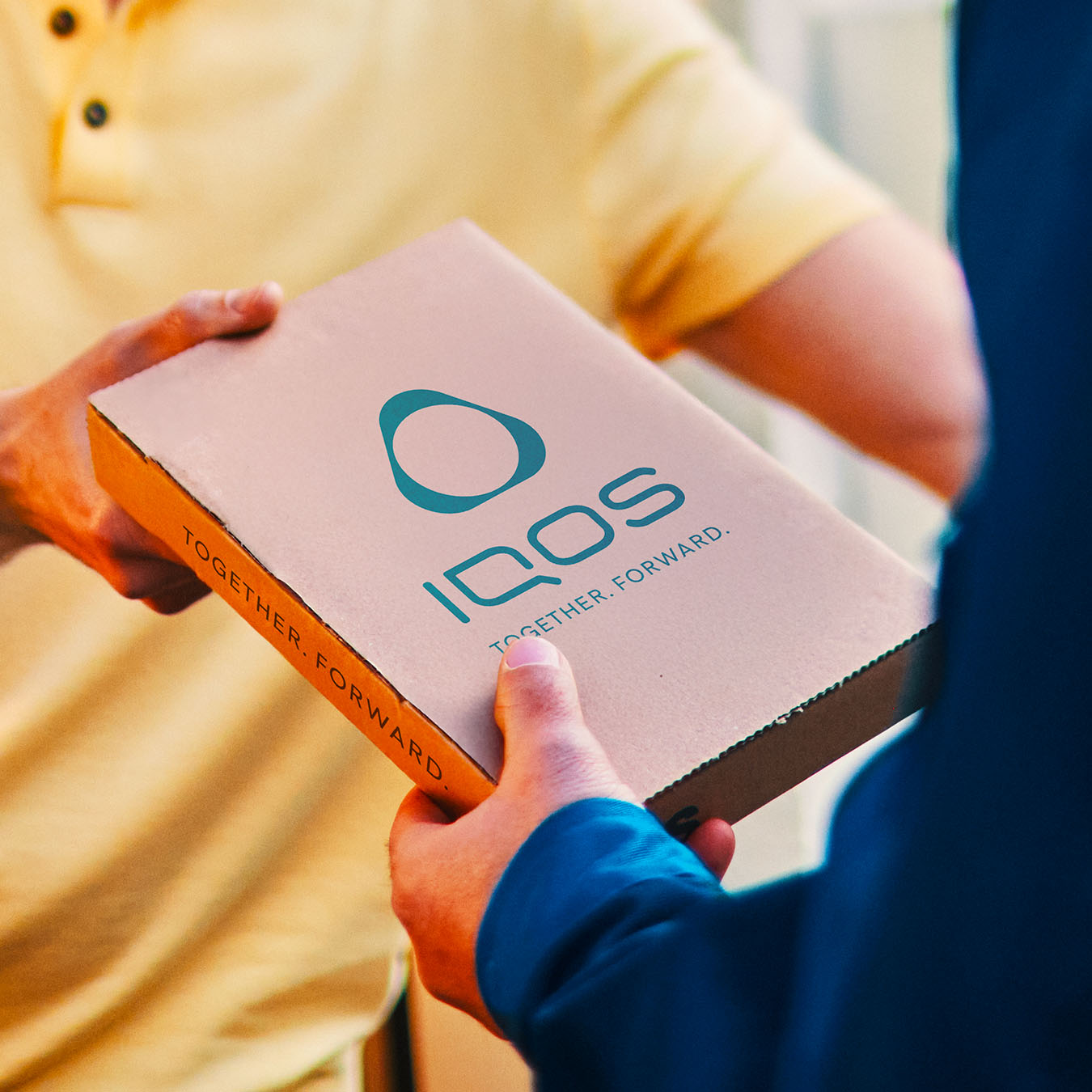 Kuriér odovzdávajúci balíček so zariadením IQOS.