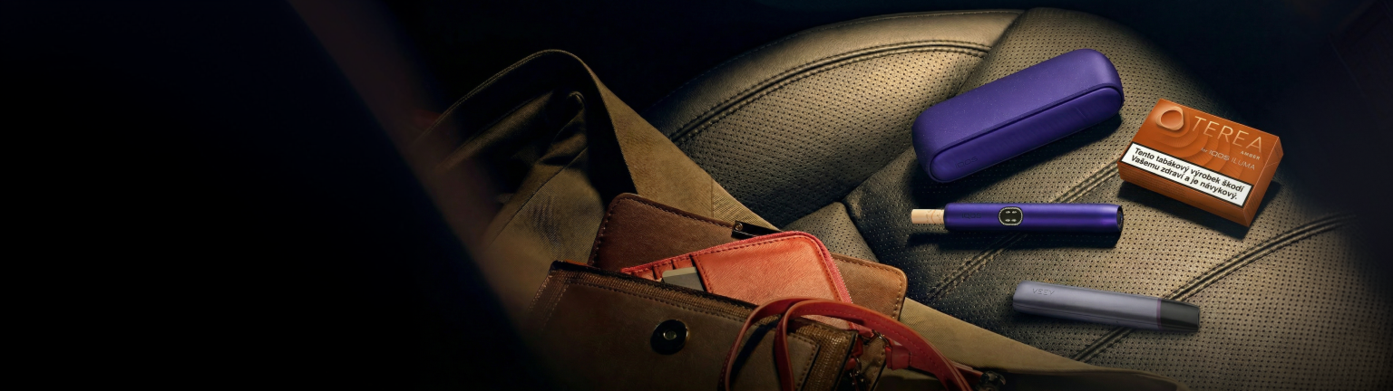 Zariadenia IQOS ILUMA i a VEEV ONE na sedadle auta.