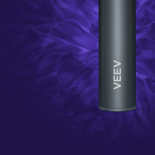 Detail tela elektronickej cigarety VEEV now ULTRA v tmavej farbe s nápisom VEEV na fialovom pozadí s ikonou štítu.