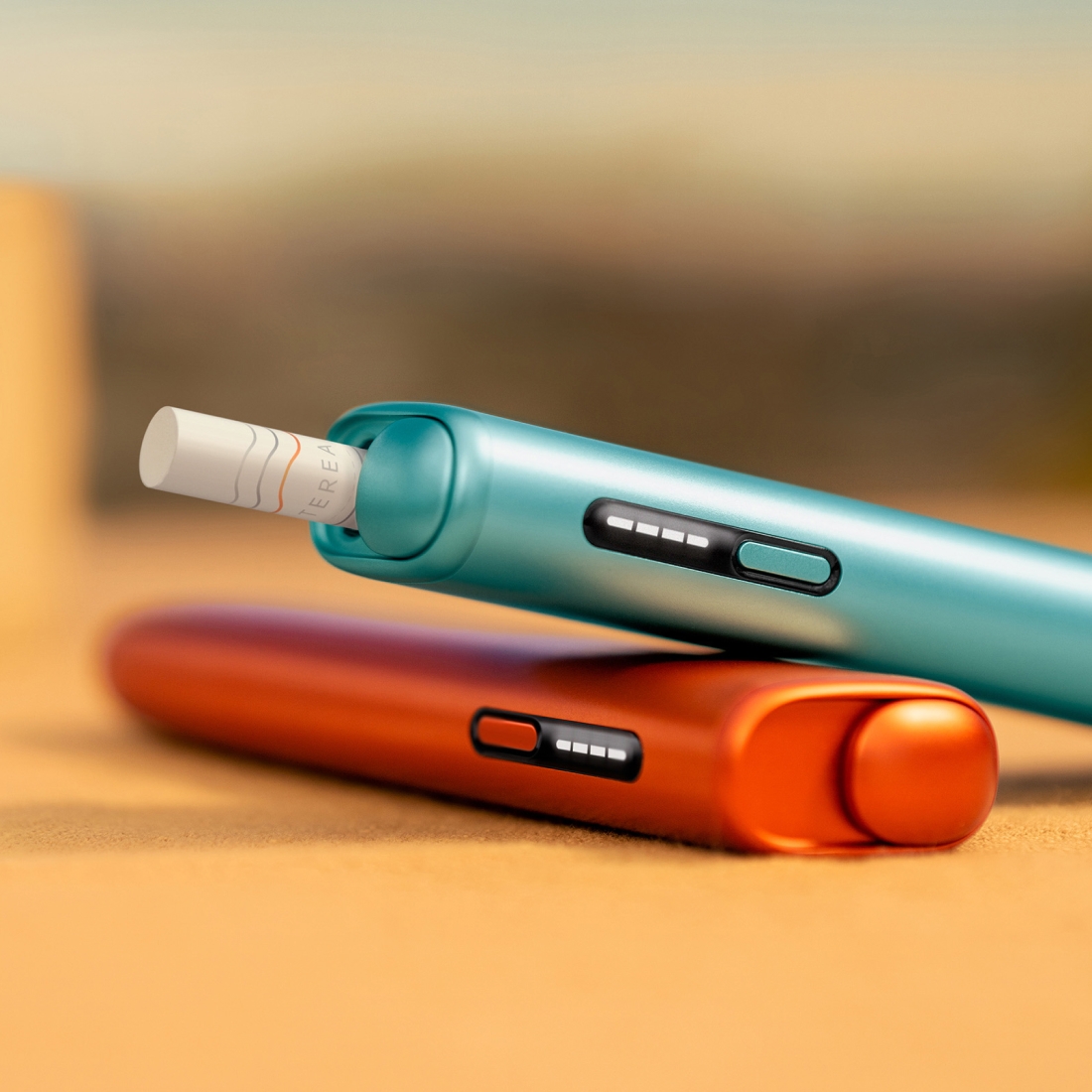 Modrý IQOS ILUMA i ONE nad tarracottovým IQOS ILUMA i ONE