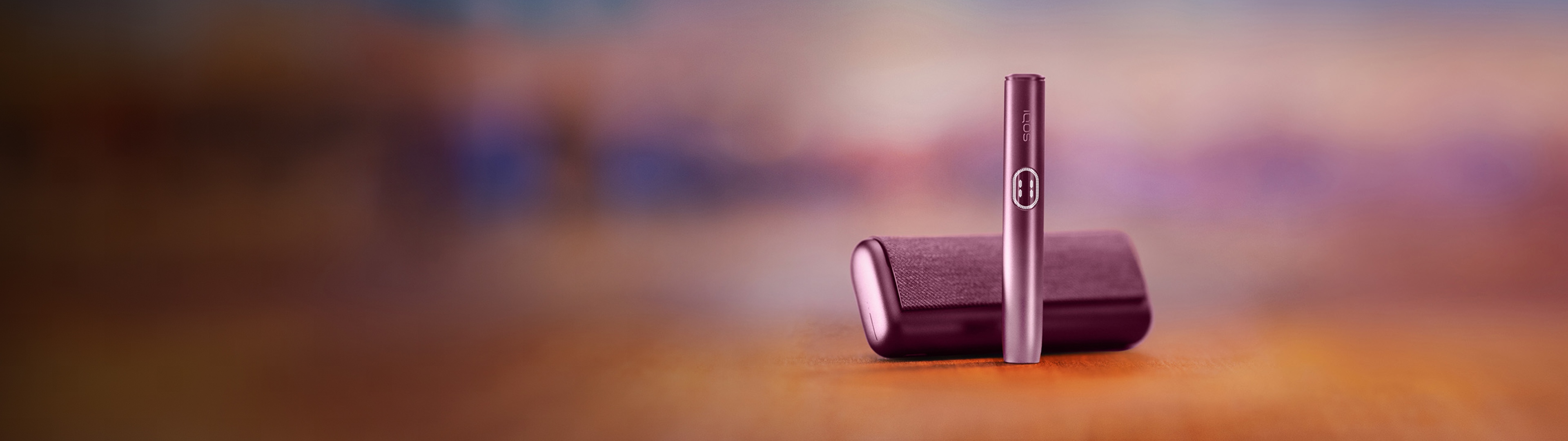 Appareil IQOS ILUMA i PRIME, debout devant son chargeur