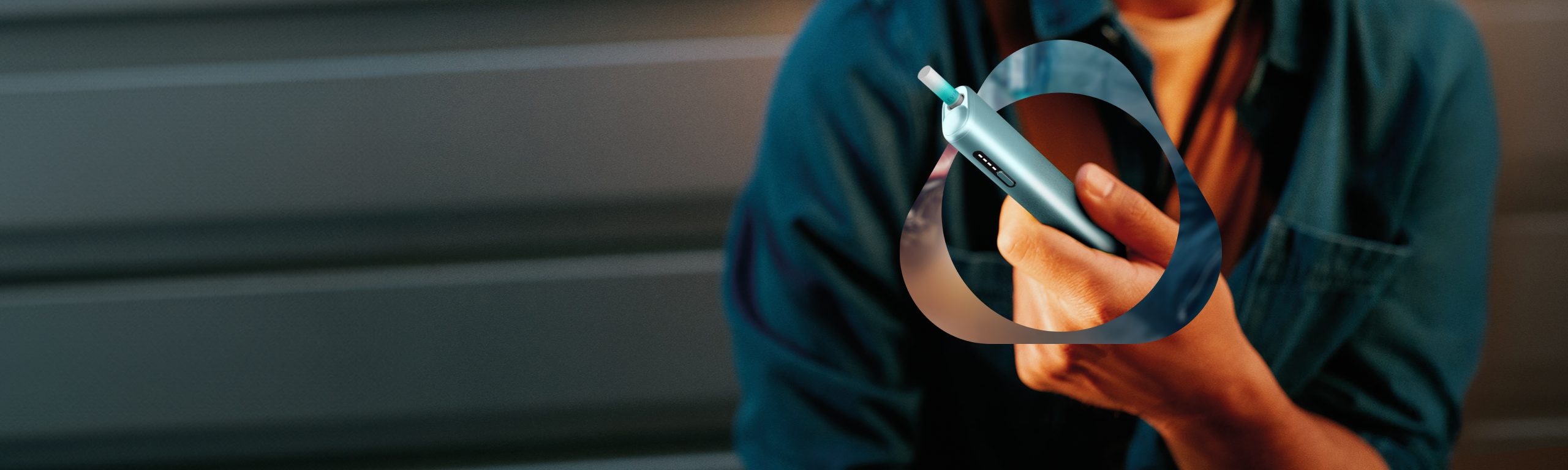 Adult user holding an IQOS heated tobacco device