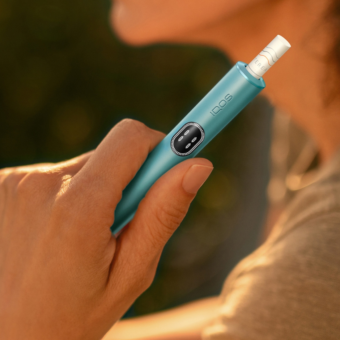 Hand holding an IQOS ILUMA i device