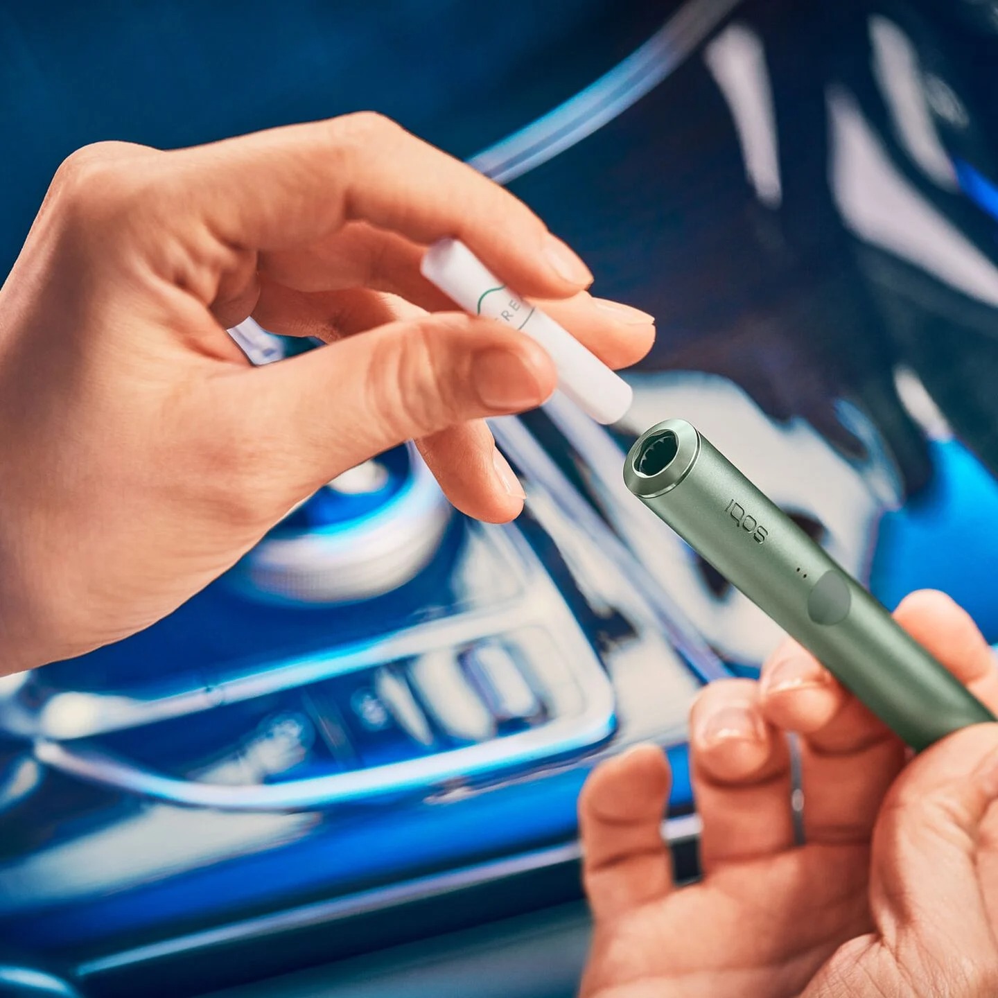 A person inserting an IQOS TEREA stick into an IQOS ILUMA device.