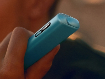 Person holding a Breeze Blue IQOS ILUMA i ONE device in hand