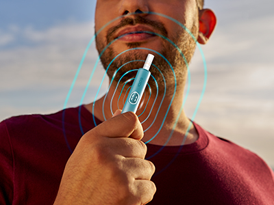 Man holding a blue IQOS ILUMA i PRIME device