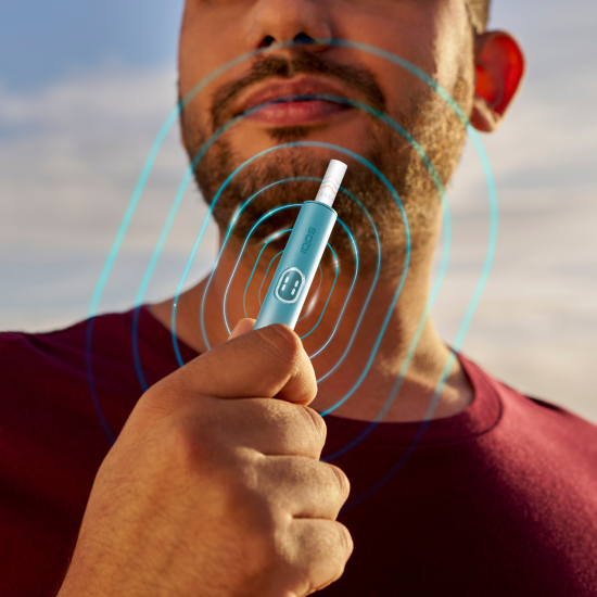 Man holding a blue IQOS ILUMA i PRIME device